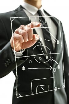 Man pointing at football field on a virtual screen Man pointing at football field on a virtual screen to explain game strategy.